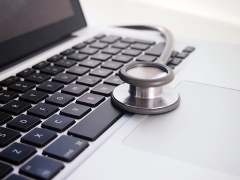 photo: stethoscope resting on a laptop keyboard